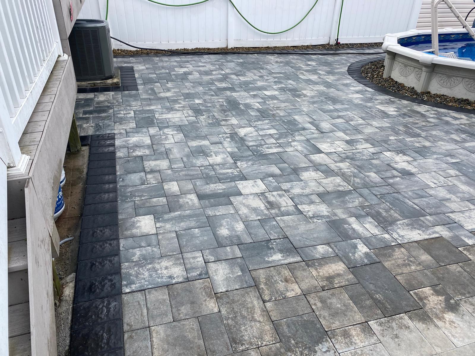 Fresh paver patio beside a pool