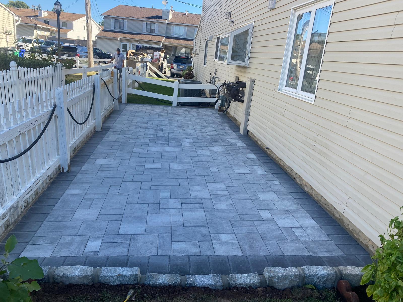 Long paver walkway between house and fence