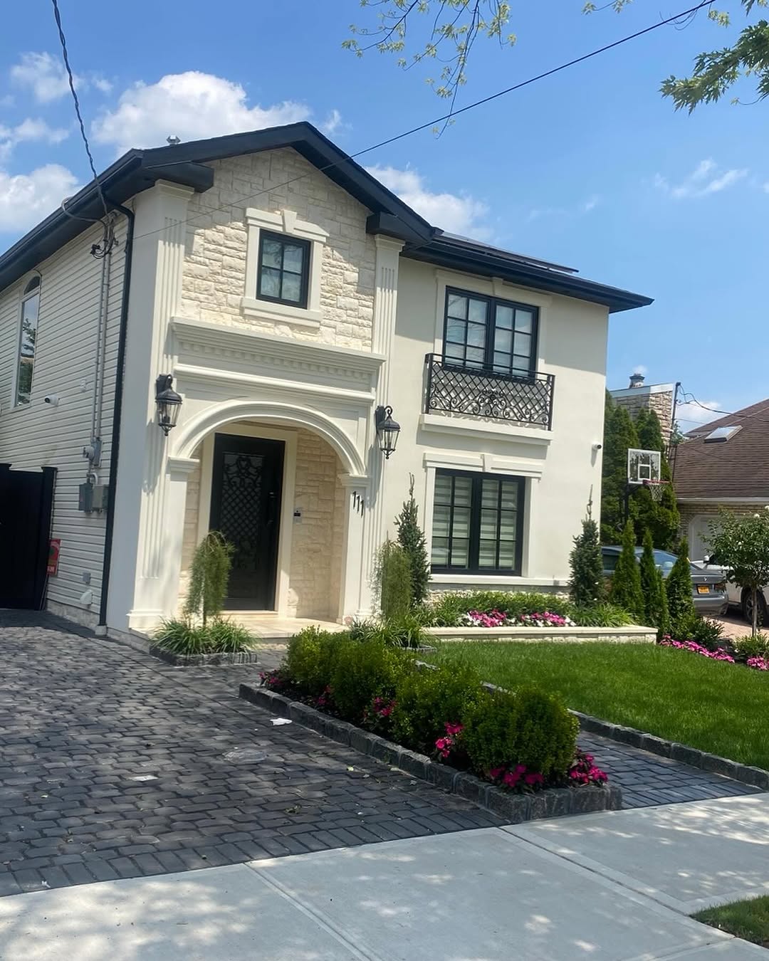 Finished house exterior after masonry, stucco, paver, and landscape work